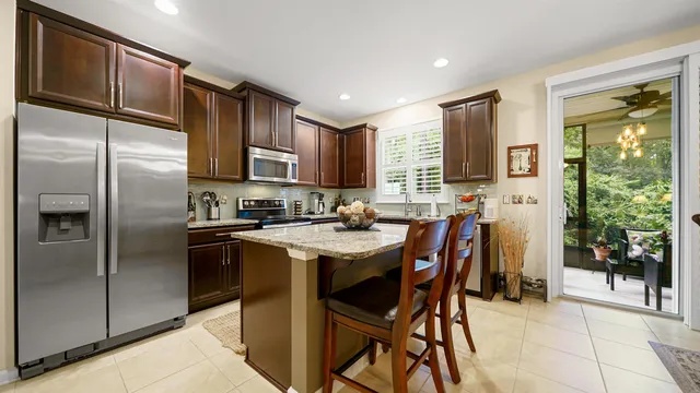 a kitchen with stainless steel appliances granite countertop a refrigerator and a stove top oven