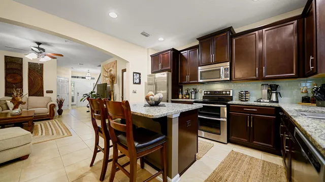 a kitchen with stainless steel appliances granite countertop wooden cabinets a stove top oven a sink and dishwasher