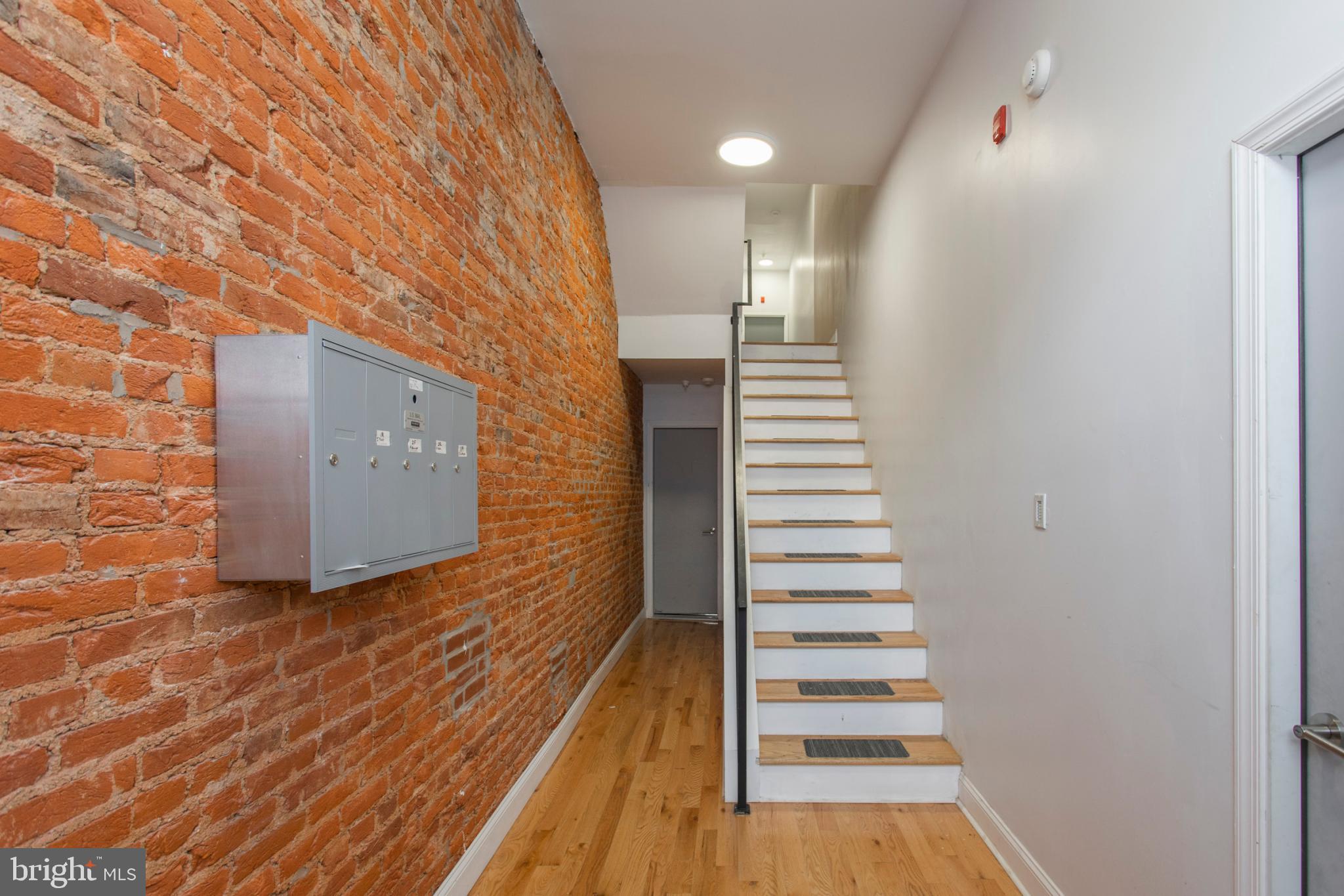 1629 Wallace Street, Unit 1R Philadelphia, PA 19130 - Photo 3 of 22 a view of a hallway with wooden floor and staircase