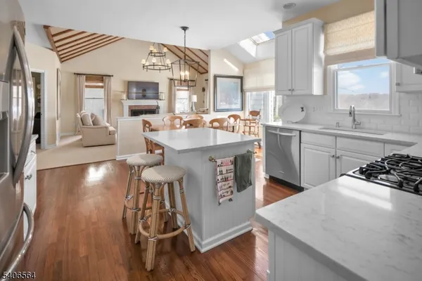 a kitchen with stainless steel appliances a sink a stove top oven a counter space and cabinets