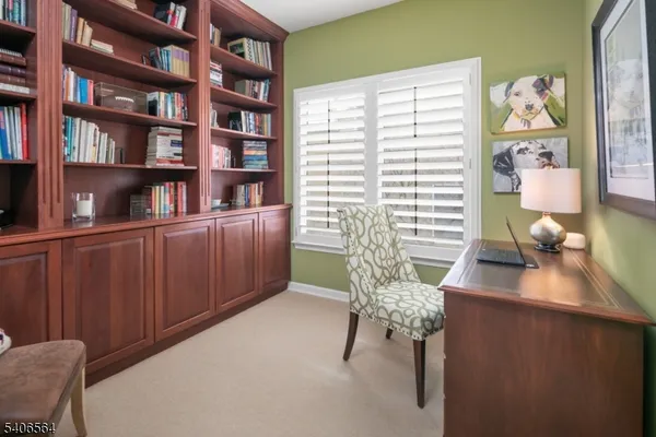 a view of a workspace with furniture and book shelf
