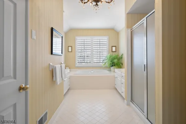 a bathroom with a tub a sink and mirror