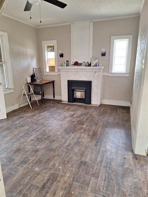 2435 Romine Avenue Dallas, TX 75215 - Photo 16 of 17 Living area featuring a fireplace with flush hearth, crown molding, dark wood-style floors, a textured wall, and ceiling fan