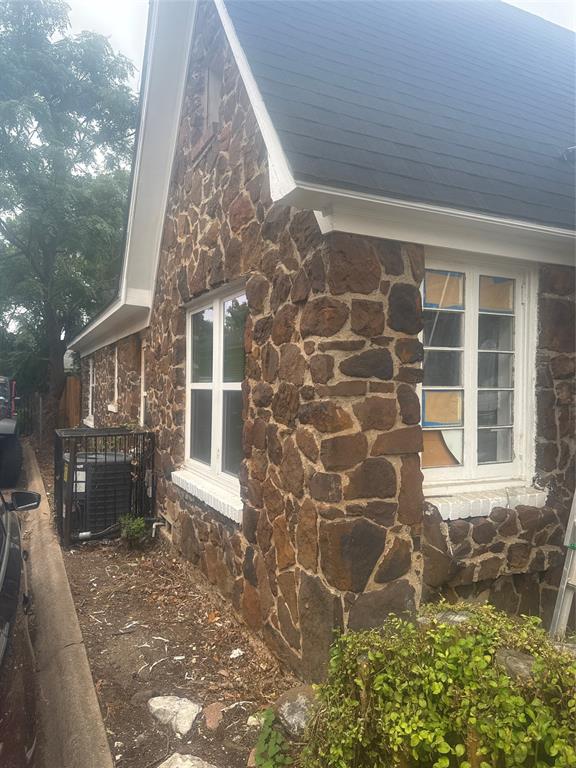 2435 Romine Avenue Dallas, TX 75215 - Photo 4 of 17 View of side of home with stone siding and a central AC unit