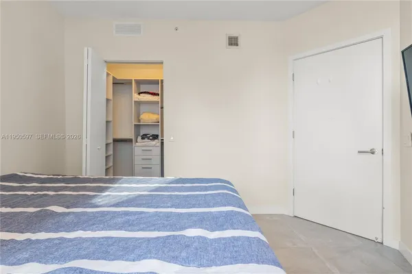 a view of a bedroom with wooden floor and cabinet