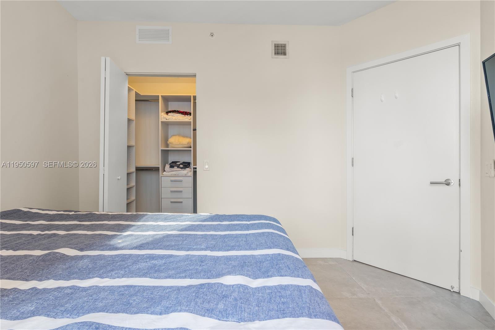 501 Northeast 31st Street, Unit 706 Miami, FL 33137 - Photo 12 of 24 a view of a bedroom with wooden floor and cabinet