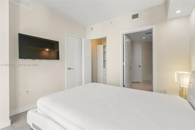 a bedroom with a bed and a flat screen tv
