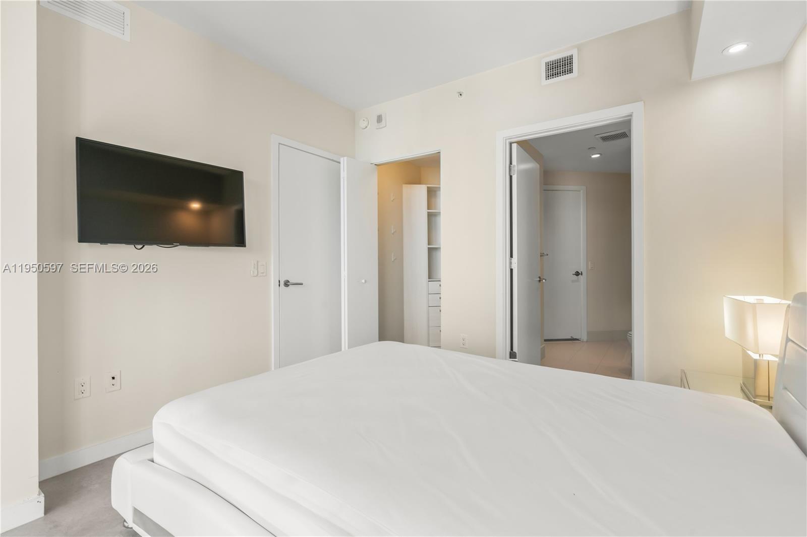 501 Northeast 31st Street, Unit 706 Miami, FL 33137 - Photo 13 of 24 a bedroom with a bed and a flat screen tv