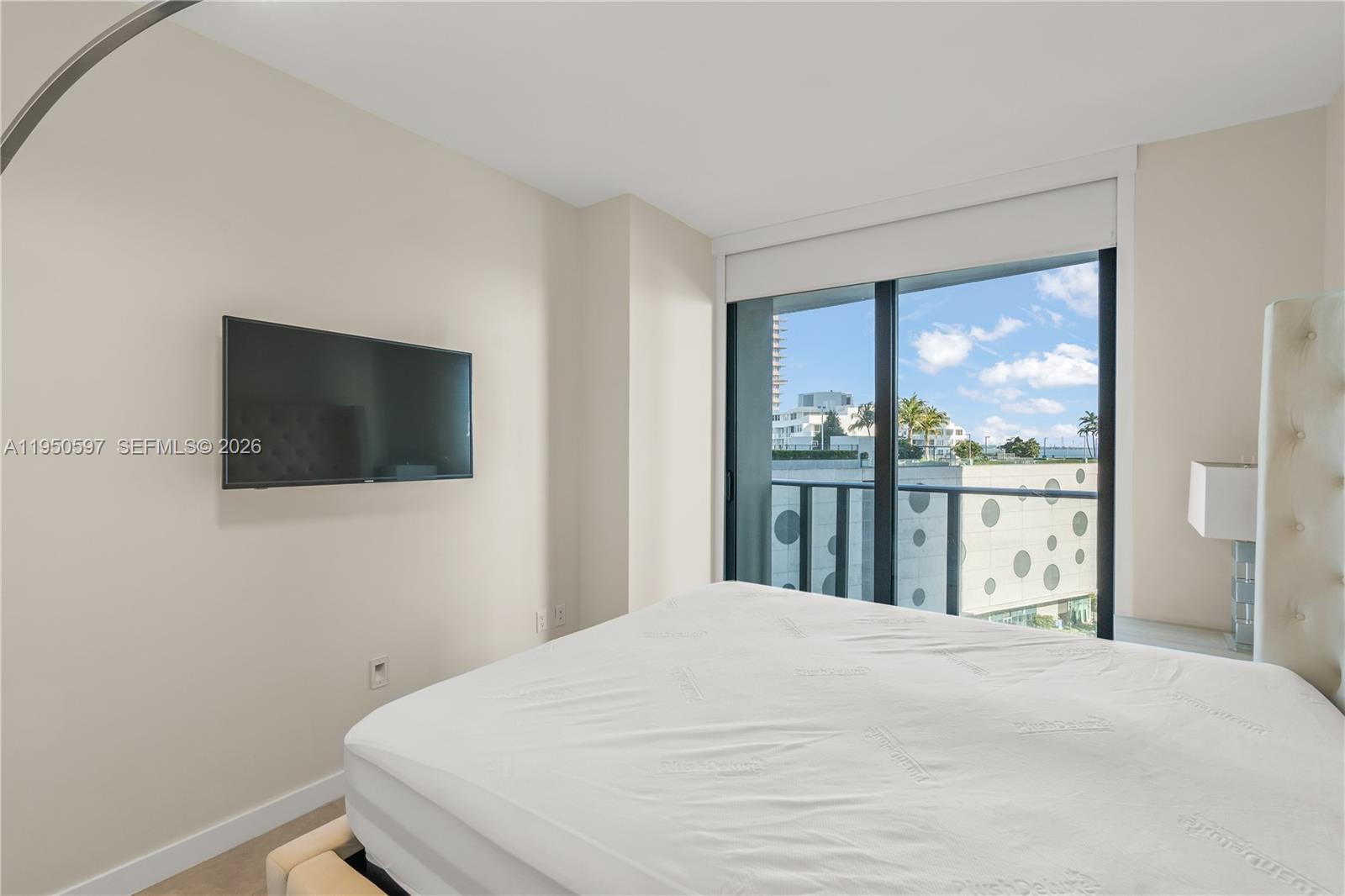 501 Northeast 31st Street, Unit 706 Miami, FL 33137 - Photo 9 of 24 a bedroom with a bed and a flat screen tv