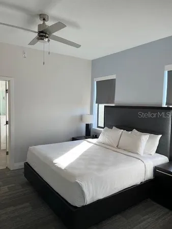 a bedroom with a bed and a ceiling fan