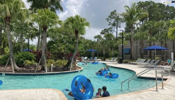 a view of a patio with table and chairs potted plants and a palm tree