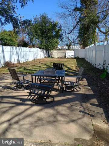 a view of a patio with table and chairs with wooden fence