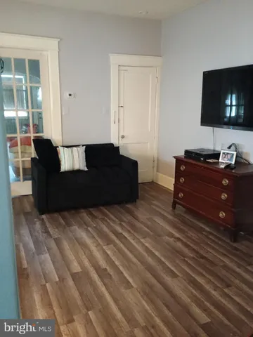 a living room with couches bookshelf and a flat screen tv