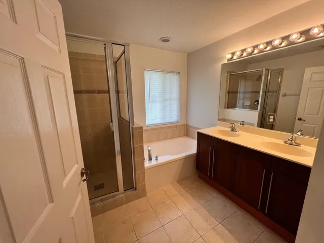 a bathroom with a double vanity sink a toilet a mirror and shower