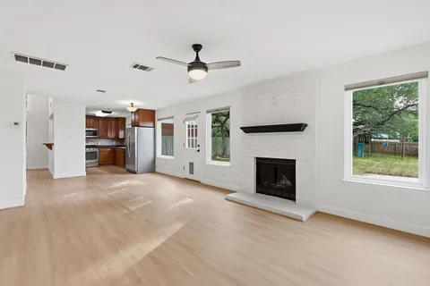 a view of a livingroom with a fireplace and windows