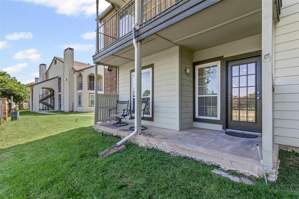5981 Arapaho Road, Unit 703 Dallas, TX 75248 - Photo 17 of 19 Back entrance to property featuring a yard and a balcony