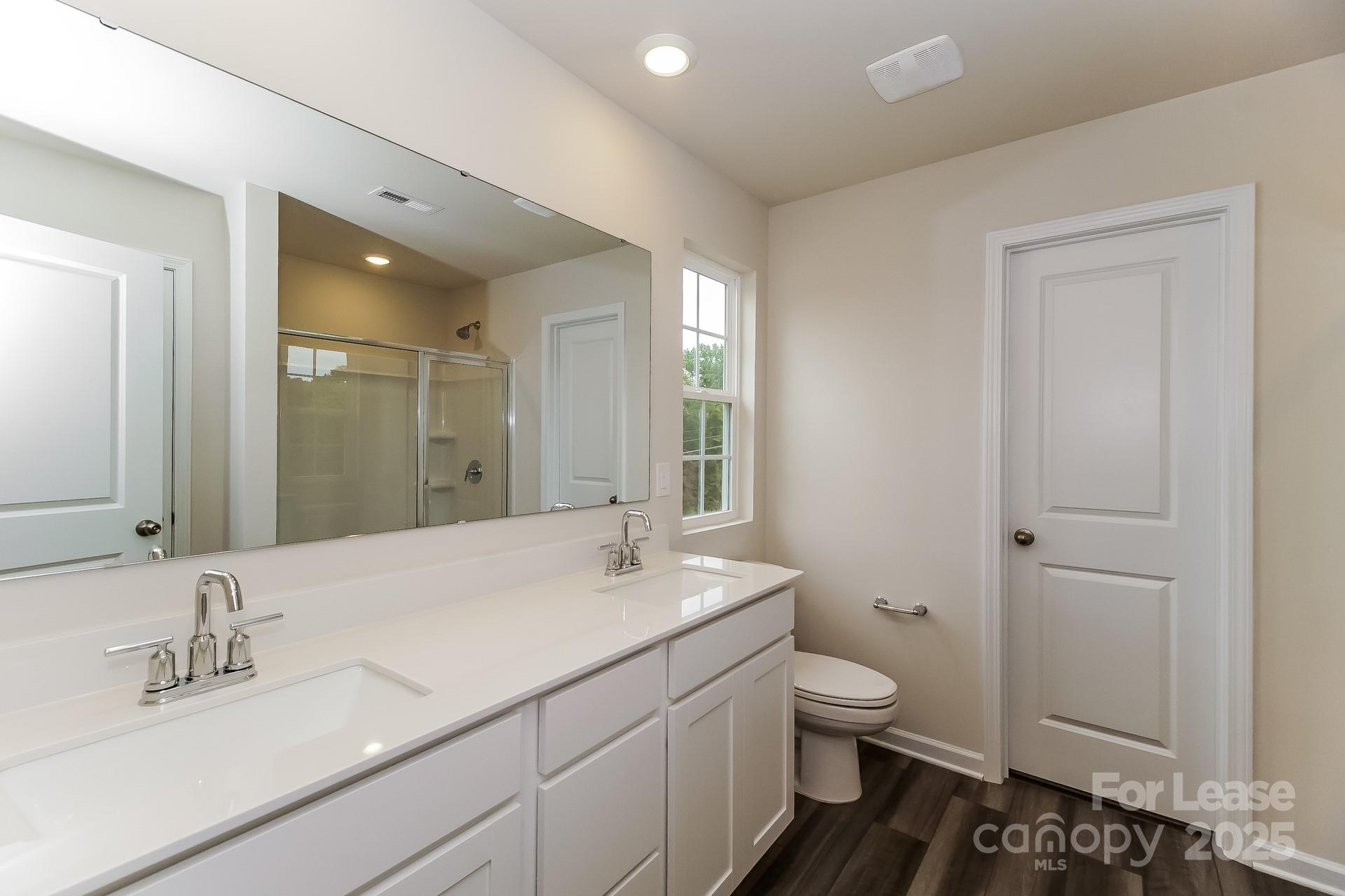 131 Arden Court Troutman, NC 28166 - Photo 13 of 23 a bathroom with a granite countertop sink a toilet and a mirror