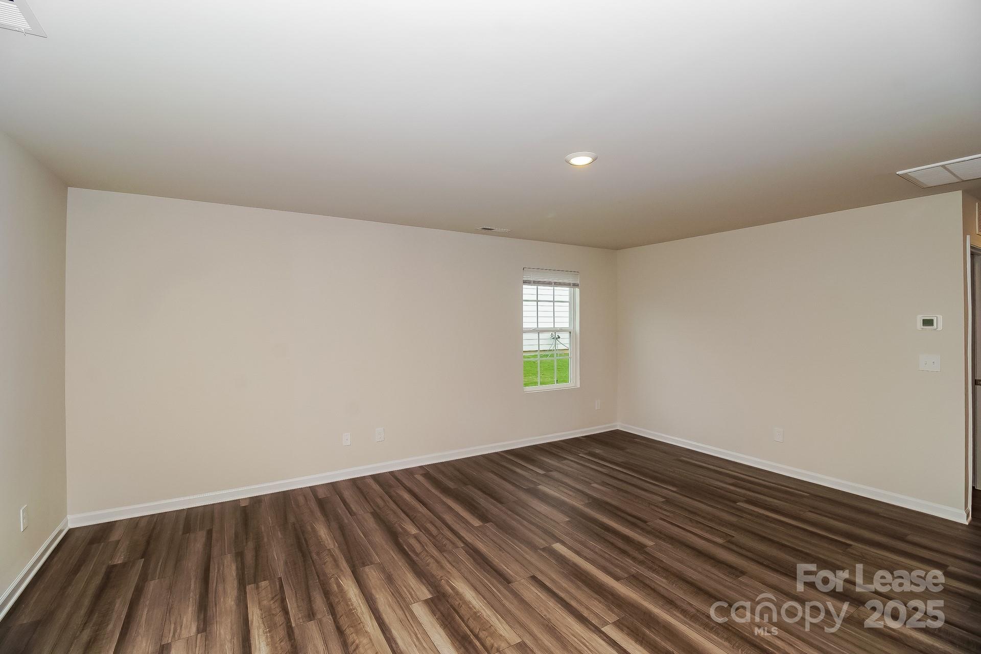 131 Arden Court Troutman, NC 28166 - Photo 6 of 23 a view of room with window and wooden floor