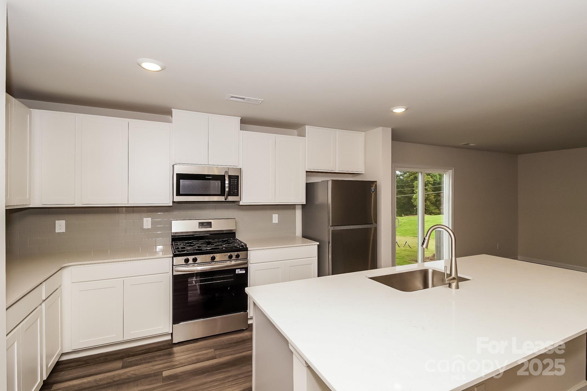 131 Arden Court Troutman, NC 28166 - Photo 9 of 23 a kitchen with stainless steel appliances a refrigerator sink and stove