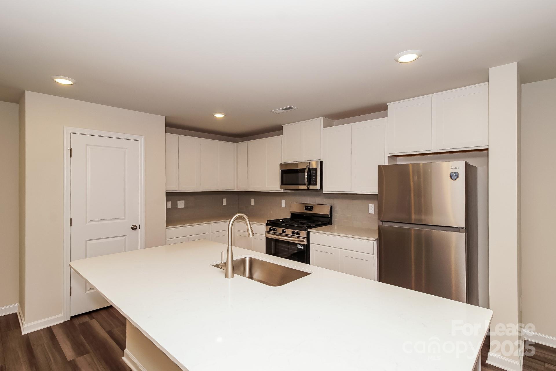 131 Arden Court Troutman, NC 28166 - Photo 10 of 23 a kitchen with stainless steel appliances a refrigerator stove microwave and cabinets