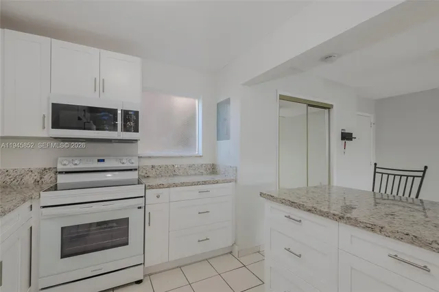 a view of a kitchen with an empty space and a stove top oven
