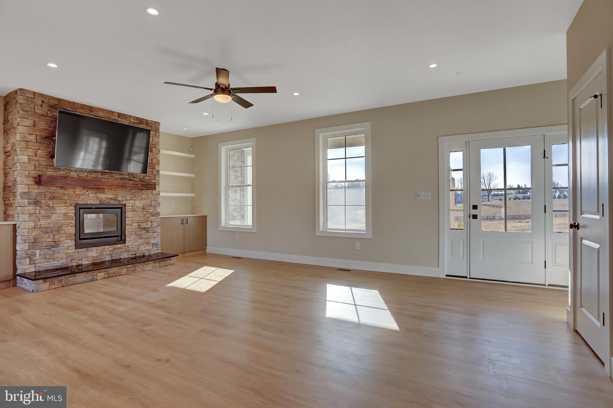 3544 Revolea Beach Road Middle River, MD 21220 - Photo 13 of 28 a view of a livingroom with a fireplace a ceiling fan and windows