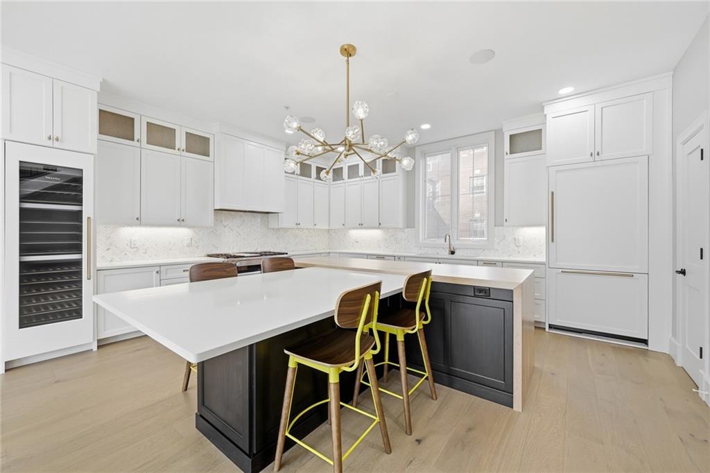 5133 Fifth Avenue Pittsburgh, PA 15232 - Photo 5 of 43 a kitchen with kitchen island a table and chairs in it