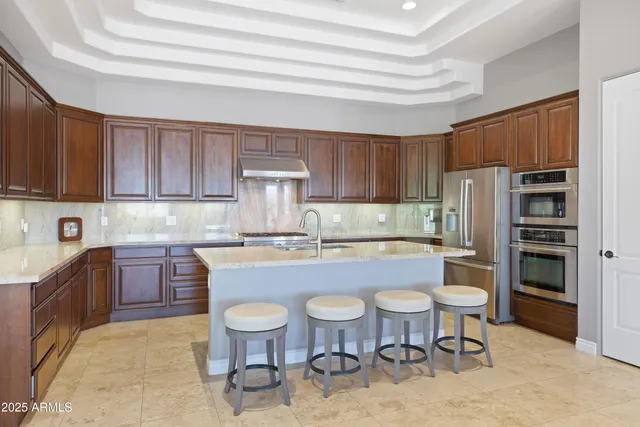 a kitchen with a table chairs refrigerator and cabinets