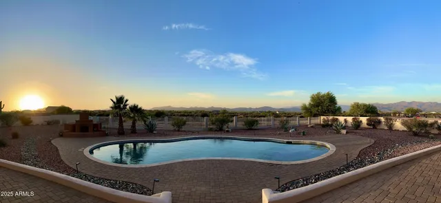 a living room with furniture and a dining table with chandelier