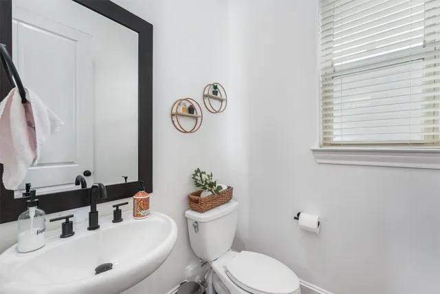 a bathroom with a sink mirror vanity and toilet