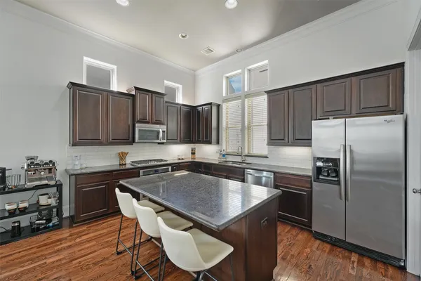 a kitchen with kitchen island granite countertop a sink stove and refrigerator