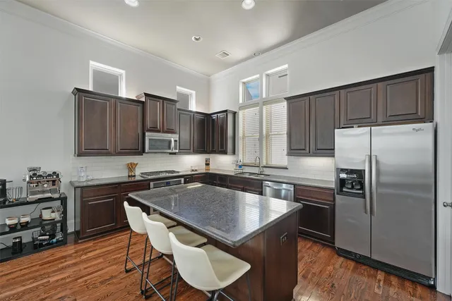 a kitchen with kitchen island granite countertop a sink stove and refrigerator