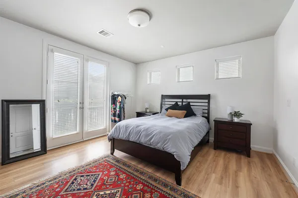 a bedroom with a bed and wooden floor