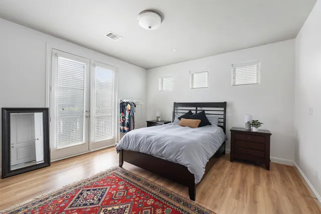a bedroom with a bed and wooden floor