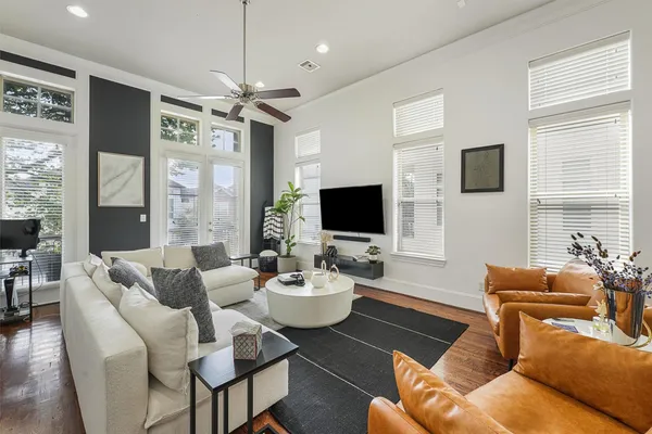 a living room with furniture a large window and a flat screen tv