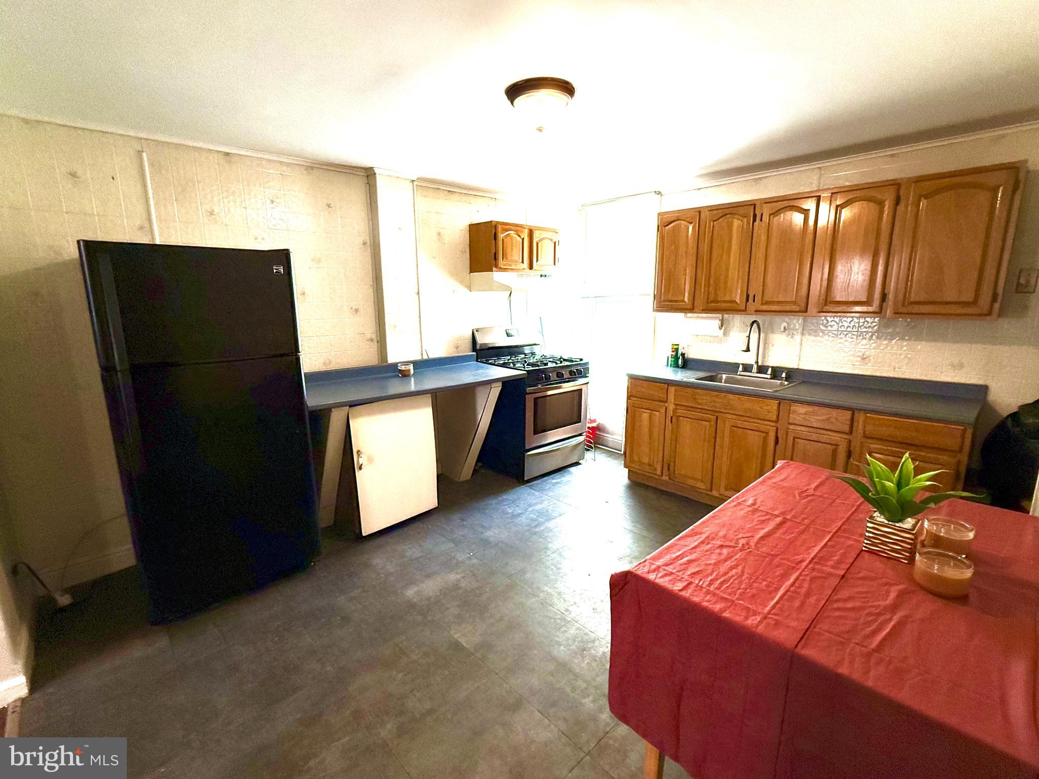 706 Dudley Street Philadelphia, PA 19148 - Photo 3 of 8 a kitchen with stainless steel appliances granite countertop a sink stove and refrigerator