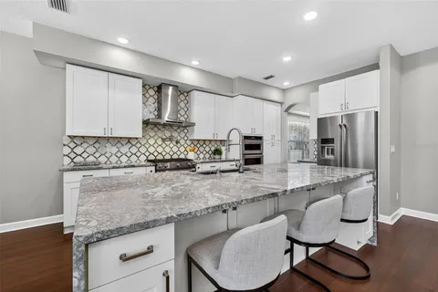 a large kitchen with cabinets wooden floor and stainless steel appliances