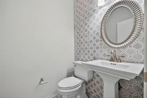 a bathroom with a granite countertop double vanity sink a mirror and a shower