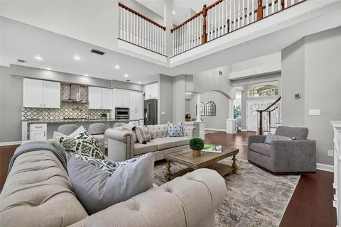 a kitchen with stainless steel appliances granite countertop a stove a refrigerator a microwave oven a sink with island and chairs with wooden floor