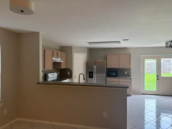 a view of kitchen with kitchen island a window a sink and a counter top space