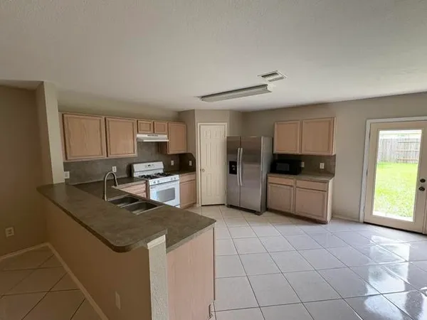 a kitchen with stainless steel appliances granite countertop a stove a sink and a refrigerator