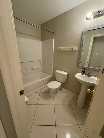 a bathroom with a toilet sink and shower