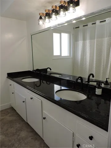 a bathroom with double sink and a mirror