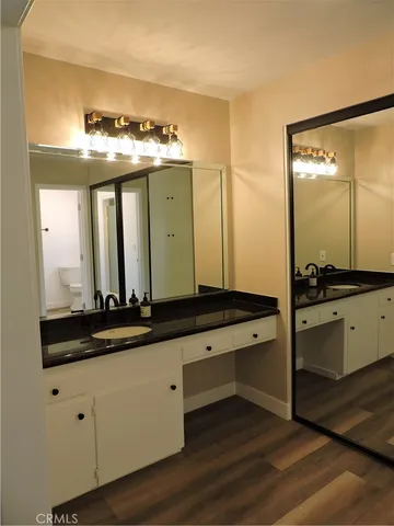 a bathroom with double vanity and a large mirror