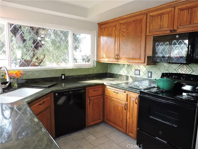 a kitchen with granite countertop a sink and a stove