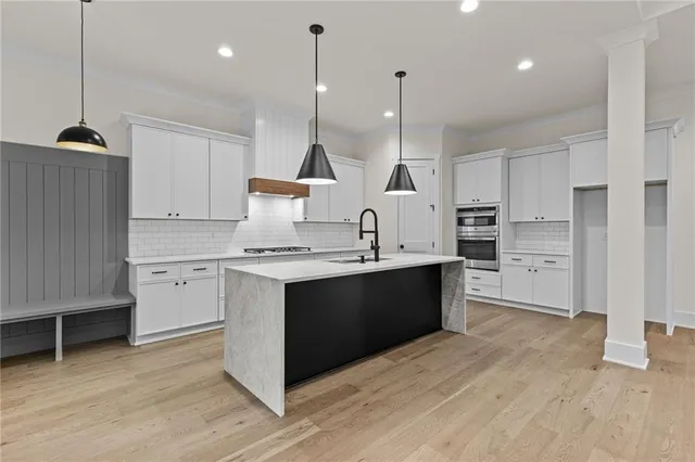 a kitchen with stainless steel appliances kitchen island granite countertop a sink a stove and a refrigerator