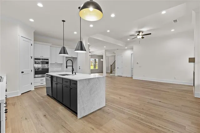 a large kitchen with stainless steel appliances kitchen island a large counter top and a wooden floors