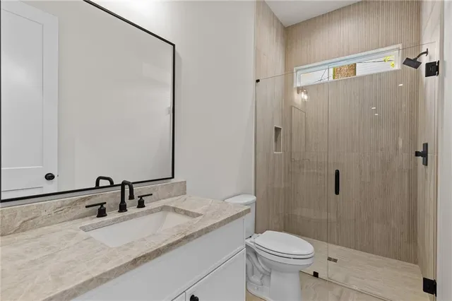 a bathroom with a granite countertop sink toilet and shower