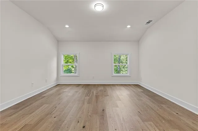 an empty room with window and wooden floor