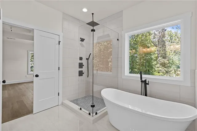 a white bath tub sitting next to a shower